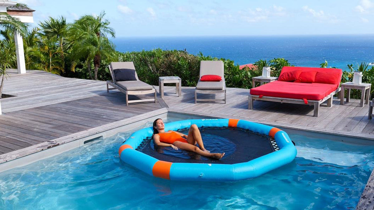 Femme allongée sur la HANA PartyPool bleue dans une piscine