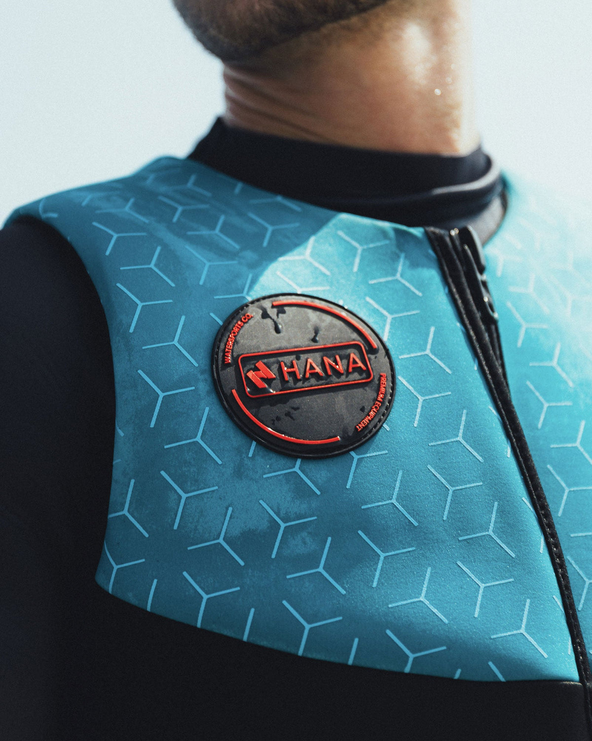 Close-up of a blue HANA vest with a hexagonal pattern worn over a wetsuit