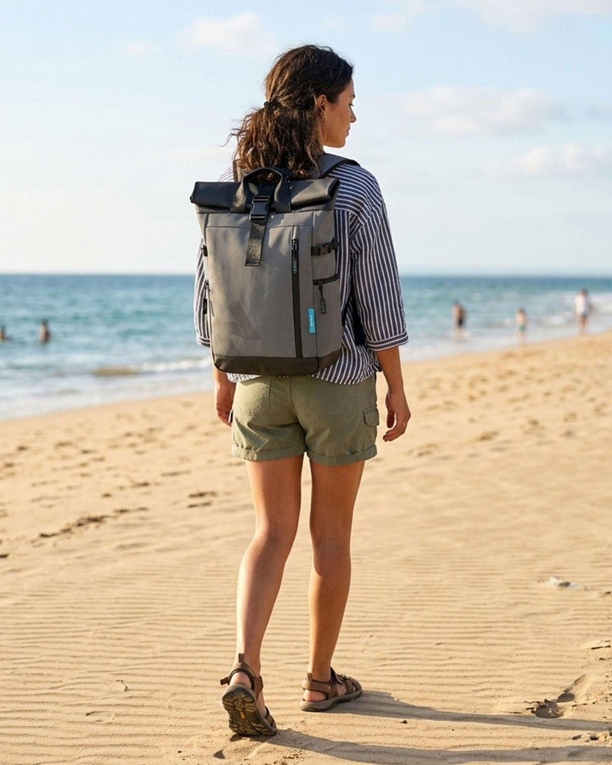 Femme marchant sur une plage avec un sac à dos HANA gris