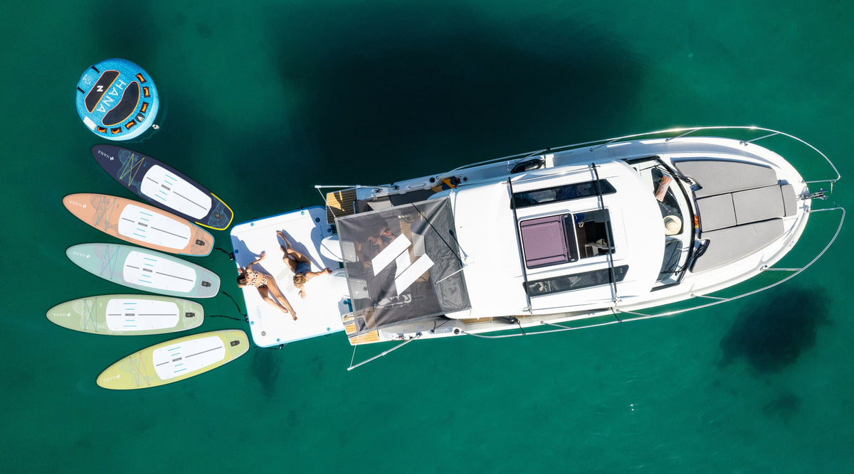 HANA California inflatable paddle boards and HANA towable tube around a boat, aerial view