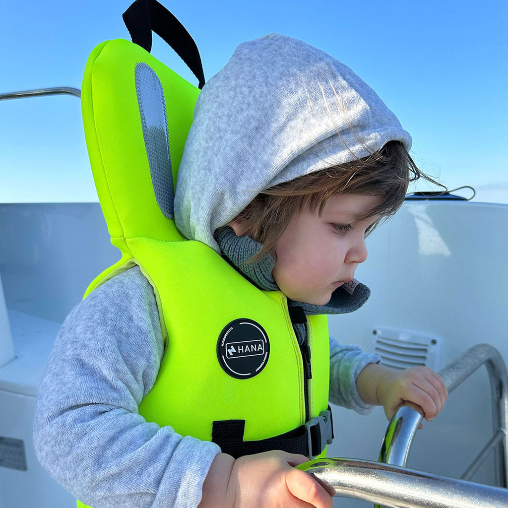 Gilet de sauvetage enfant HANA Neo Safety Vest 100 N – porté par un enfant à bord d'un bateau