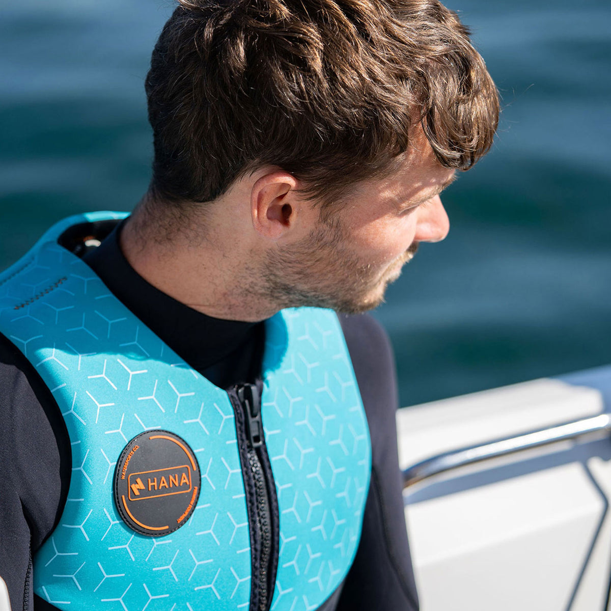 HANA Neo Vest 50 N life jacket, Light Blue – close-up of the HANA badge, worn by a man