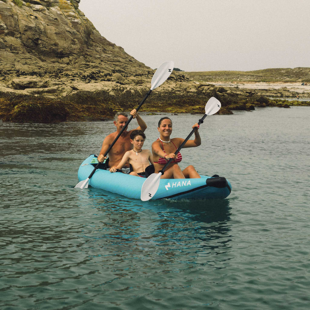 Family paddling a HANA inflatable kayak by the sea