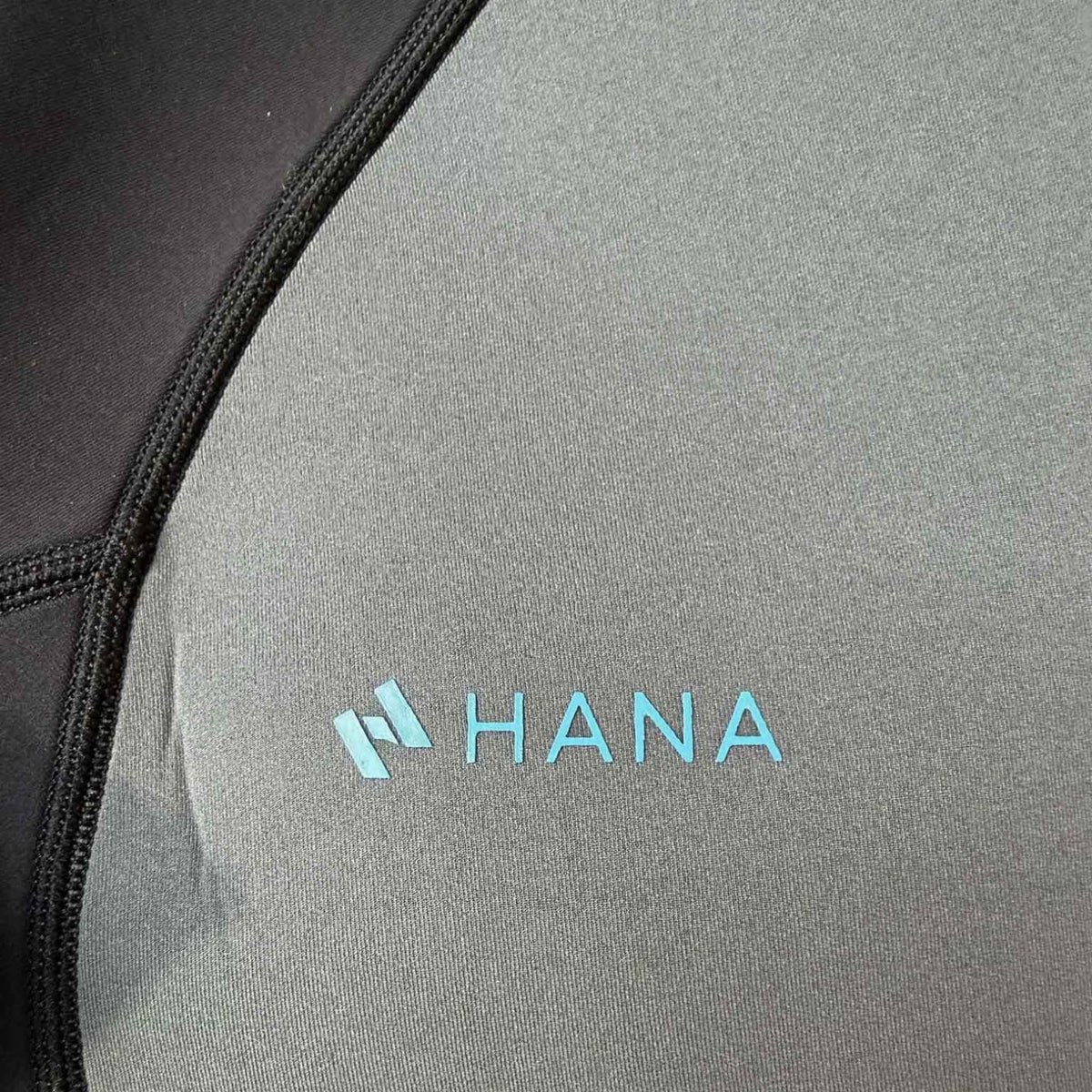 Combinaison néoprène enfant HANA Kids – détail du plastron gris graphite et du logo HANA