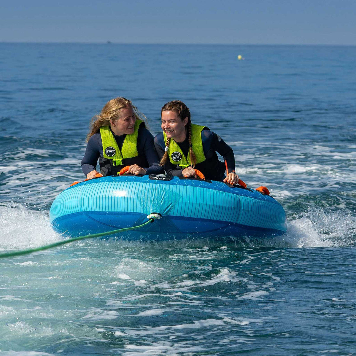HANA Moon towable tube – two riders being towed at sea