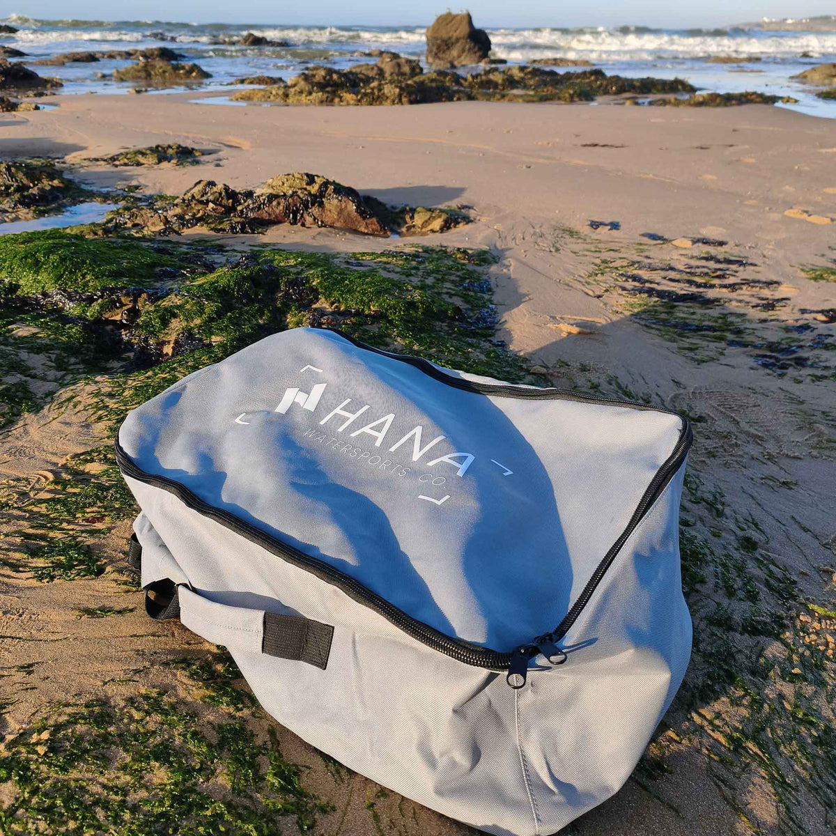 HANA Premium inflatable surfboard carry bag on the beach
