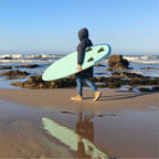 Surfeur marchant sur la plage avec la planche de surf gonflable HANA Premium 6'6