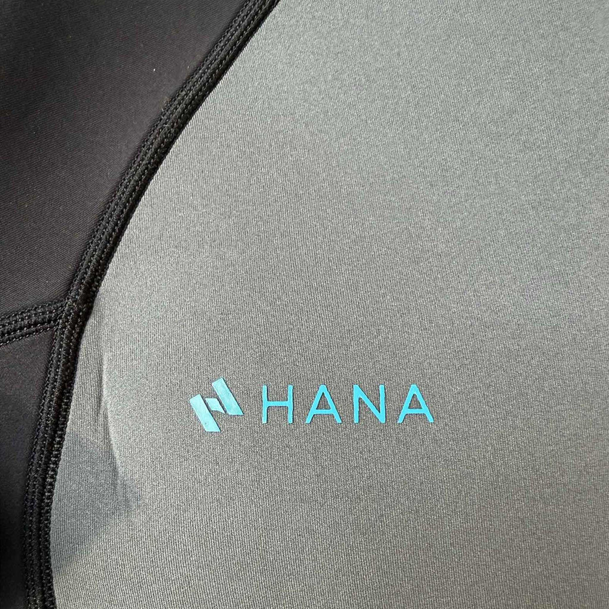 HANA Waimea men’s 3/2 mm shorty wetsuit in Grey – close-up of the grey chest panel and HANA logo