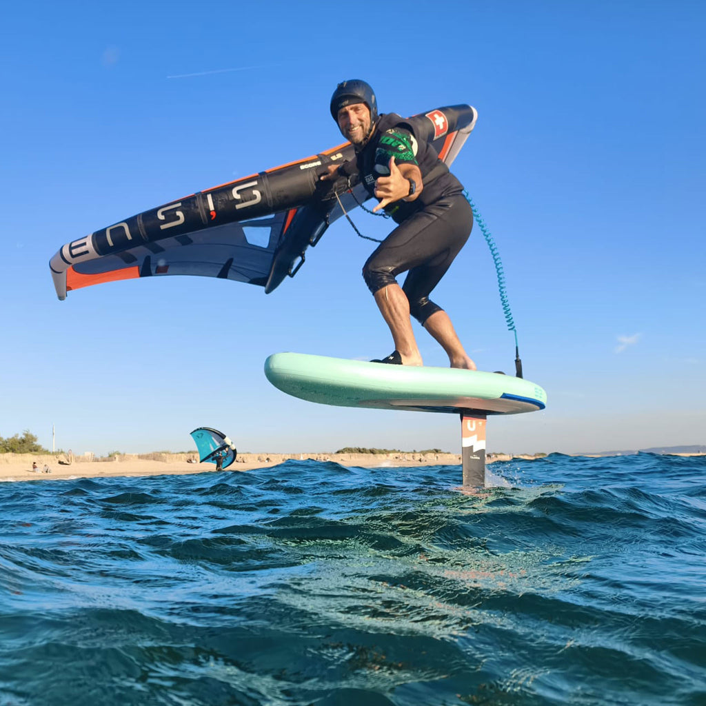 Rider en wingfoil volant au-dessus de l’eau avec la planche HANA Premium