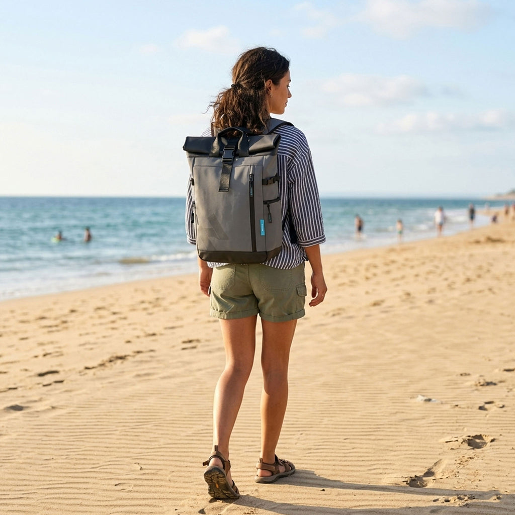 Woman wearing the HANA XPlorer 25L backpack in Dark Grey on the beach